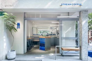 Modern coffee shop with concrete interior design, featuring a sleek, minimalist counter and seating area.
