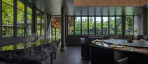 Modern restaurant dining room featuring stone, wood, and glass