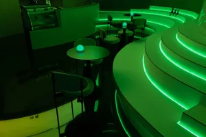 A modern industrial bar or lounge area with concrete flooring and seating.