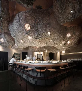 Interior of a modern, industrial-style restaurant featuring concrete and metal materials.