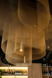 A close-up view of metal mesh ceiling panels in a restaurant setting.