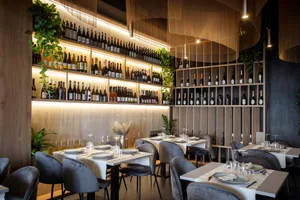 A stylish modern wine bar with wooden accents and a variety of bottles on shelves.