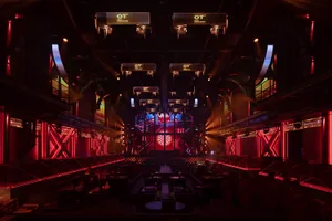 A large, modern nightclub with vibrant LED lighting and a central stage area.