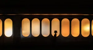 A retail storefront with glass panels and warm lighting at night.