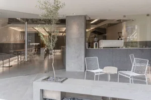 Modern industrial-style coffee shop with concrete elements and minimalist design.