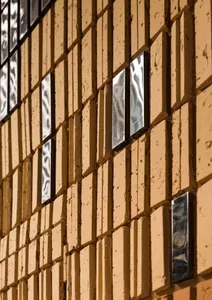 Modern exterior featuring a pattern of brick tiles with metallic insets for a unique design.