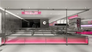 A sleek and modern coffee shop with metallic accents and pink lighting.