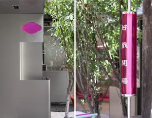 A modern commercial space featuring metal cladding with a cloud-shaped decoration and a pink cylindrical object with Japanese