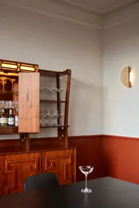 A modern dining room bar with wooden shelves and glasses.
