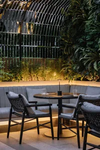 A modern dining table with a built-in plant and designer chairs.