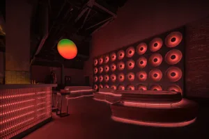 A modern industrial bar with concrete elements and illuminated metal features.