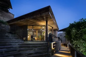 A modern restaurant exterior with wooden portions and glass walls.