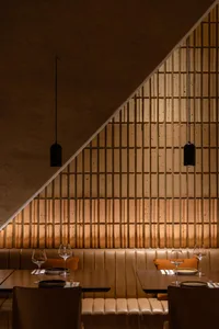 A modern restaurant interior with brown leather seating and a warm, cozy atmosphere.