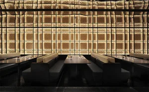 Modern restaurant interior with textured paneled walls and matte black furniture.