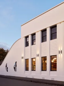 Modern white exterior of a house with white painted walls and concrete columns.