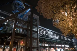 夜間零售環境，展示發光招牌與現代玻璃建築。