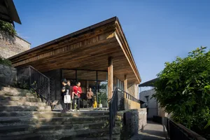 A wooden building with stone stairs and a glass door.
