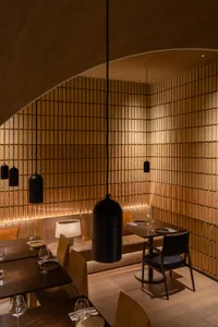 A minimalist restaurant interior decorated with natural wood materials, featuring sleek furniture and a warm, inviting atmosp