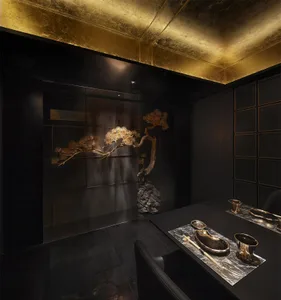 Modern restaurant interior featuring black stone accents and gold lighting fixtures.
