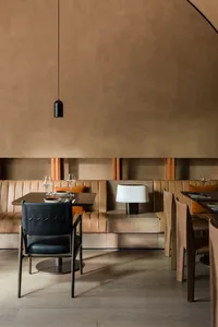 Modern restaurant table with a wooden table and leather chairs.