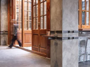 A modern coffee shop interior featuring a concrete floor, brick walls, and wooden accents.