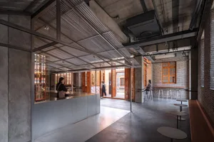Modern industrial restaurant interior featuring metal, concrete, and brick materials.
