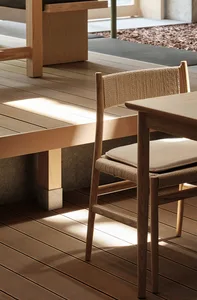 Minimalist interior design featuring wooden furniture with a woven rope backrest cushion.