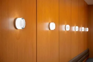 Modern minimalist corridor featuring metallic wall-mounted light fixtures.