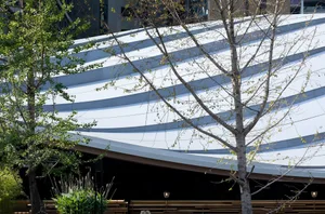 View of a modern building exterior featuring layered metal cladding.