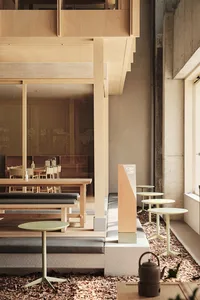 Modern cafe interior with wooden tables and concrete accents.