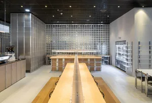 Wooden coffee shop seating area with a counter and tables.