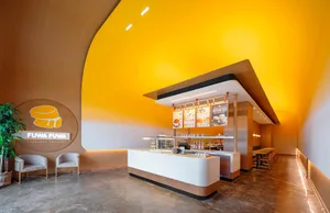 A bright, modern coffee shop interior featuring sleek surfaces and contemporary design elements.