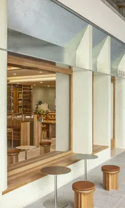 Modern coffee shop interior with wooden furniture and large glass windows