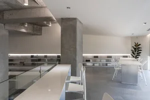 A modern office space with concrete walls and glass furnishings
