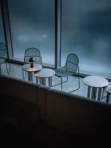 A modern restaurant interior with metal furniture and round tables.