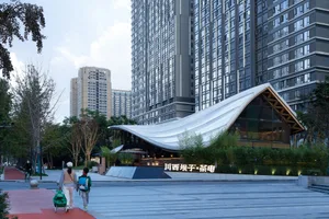 A modern urban architectural scene featuring metallic glass, concrete, and greenery.