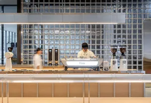 Coffee shop interior featuring a minimalist counter with glass tiles.