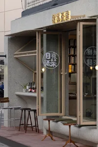 Modern coffee shop exterior with concrete window frame and glass panes.