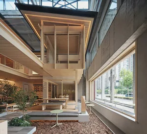 Modern interior space with wooden structures, glass walls, and concrete elements.