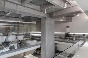 This office features modern, minimalist design with concrete walls and glass partitions.