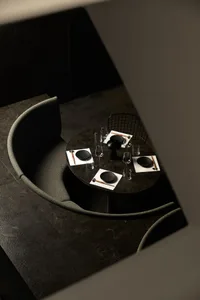 View of a modern industrial restaurant setting with dark-toned materials and minimalist design.