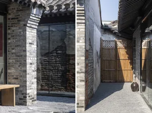 Modern brick interior with glazed walls, wooden accents, and gravel pathway.