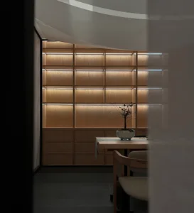 A modern interior room featuring a wooden table, shelves, and minimalist design.