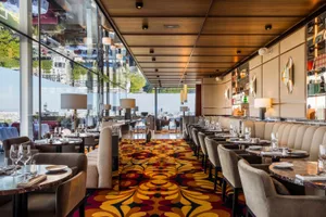 Modern restaurant interior featuring elegant furniture, marble accents, and warm lighting