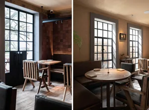Modern restaurant interior with wooden tables and chairs, leather seating, and metal accents.