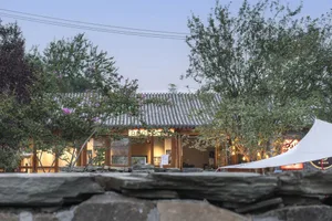 傳統建築餐廳，石瓦屋頂搭配木質外觀。