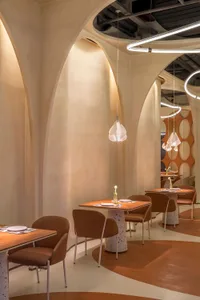 Modern restaurant interior with terrazzo flooring and leather chairs