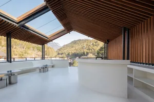 Modern, minimalist coffee shop with concrete flooring and wooden ceiling.