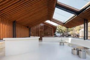 Modern coffee shop featuring wooden beams and a glass-covered deck.