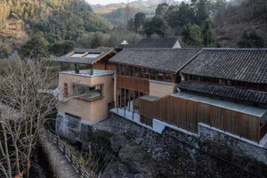 Modern residential interior with wood and concrete materials, set amidst a natural landscape.